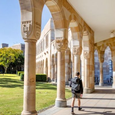 a view of a colonaded walkway next to green lawn